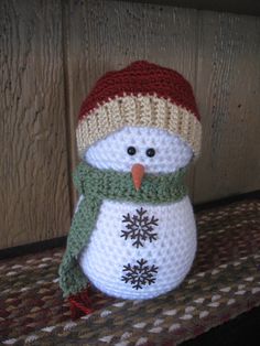 a knitted snowman sitting on top of a table