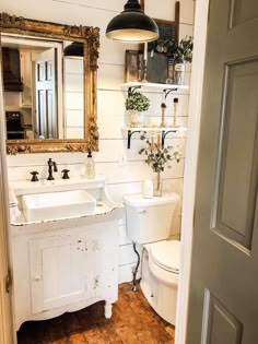 a bathroom with two sinks, a toilet and a large mirror on the wall above it