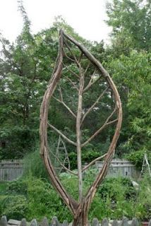 a wooden sculpture in the middle of a garden