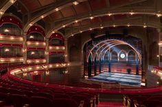 an empty theatre with red seats and lights