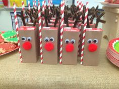 some brown paper bags with red noses and candy canes in them on a table