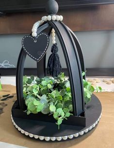 a potted plant with a heart hanging from it's side on top of a table