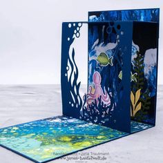 an open card with underwater scene on the front and back sides, cut out from blue paper