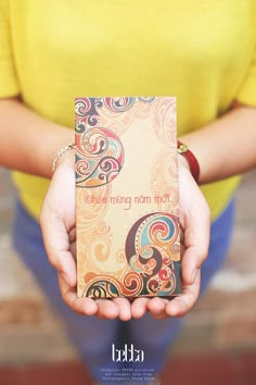 a person holding a small box in their hands with the words mom mum written on it