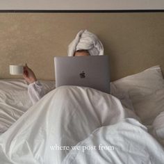 a person laying in bed with a laptop