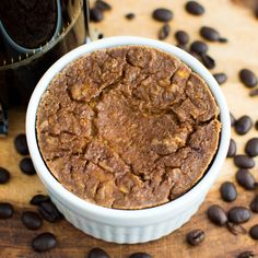 a close up of a bowl of food on a table with coffee beans next to it