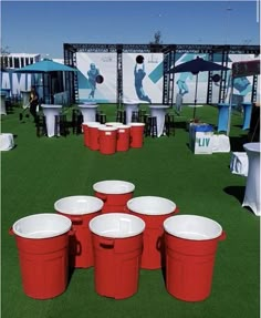 red and white buckets sitting on top of a green field