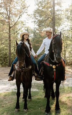 a man and woman riding on the backs of horses