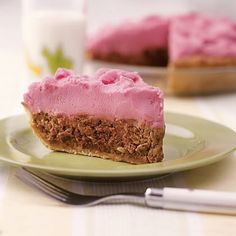 a piece of cake sitting on top of a green plate next to a glass of milk