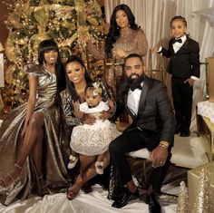 the family is posing in front of a christmas tree