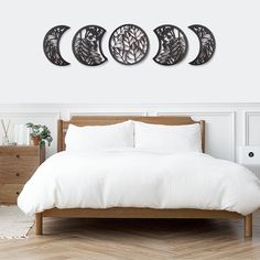 three circular metal wall art pieces on a white wall above a bed in a bedroom