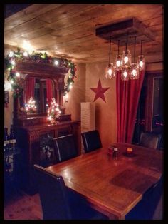 a dining room table and chairs with christmas lights on the wall behind it, along with a mirror