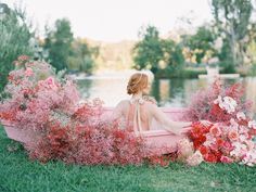 a woman sitting in a pink boat surrounded by flowers