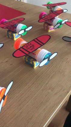 the toy airplanes are made out of toilet paper on the wooden table with red and green markers