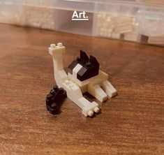 a lego cat sitting on top of a wooden table