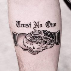 a man's leg with a tattoo on it that says trust no one and an image of a hand holding a knife