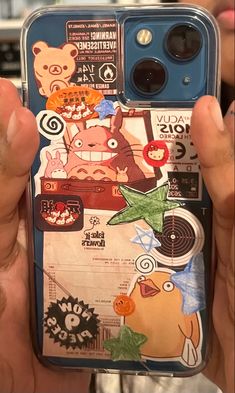 someone holding up their phone case with stickers on it