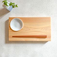 chopsticks and bowl sitting on a wooden tray