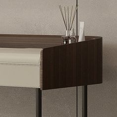 a desk with a white leather seat and some reeds on it's side