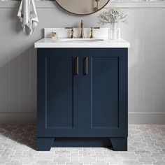 a bathroom vanity with blue cabinets and a round mirror