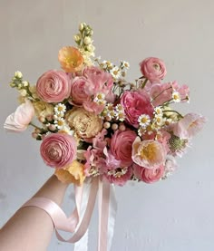 a person holding a bouquet of flowers in their hand