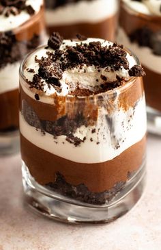 three desserts in small glass dishes on a table with white and brown frosting