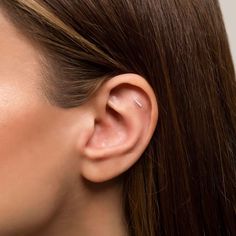 a close up of a woman's ear with the middle part of her nose visible