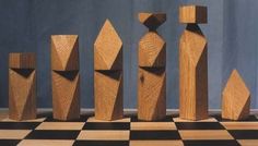 several wooden sculptures on a checkered floor