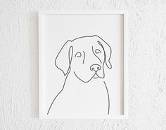 a black and white drawing of a dog's face in a frame on the wall