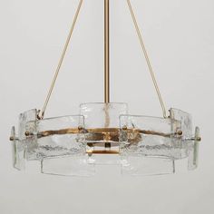 a chandelier made out of glass and brass with three lights hanging from it