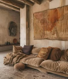 a living room filled with lots of furniture next to a large painting on the wall