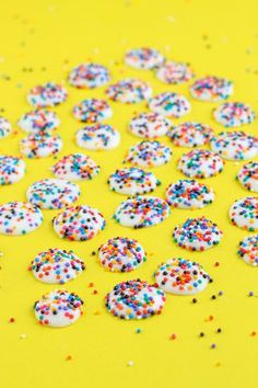 sprinkles and confetti are scattered on a yellow surface