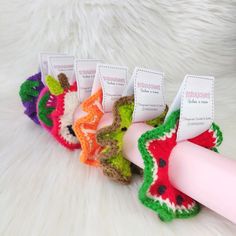 four crocheted toothbrush holders with labels on them