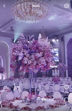 an elegant wedding setup with purple flowers and crystal chandelier