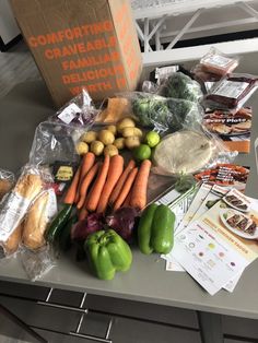 the table is full of fresh produce including carrots, potatoes and green peppers