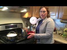 a woman standing in front of an oven with pots and pans on the stove