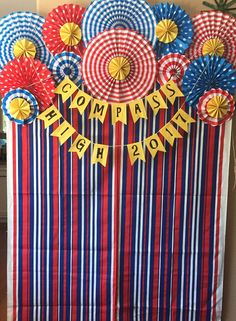 a red, white and blue striped banner with paper flowers