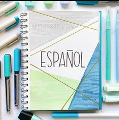 a notebook with the word espanol written on it surrounded by pens and markers