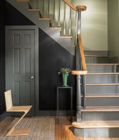 a room with some stairs and a vase on the floor next to a table in front of a door