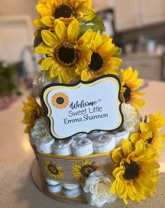 a cake with sunflowers on it and a welcome sign in the top corner