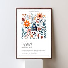 an art print with flowers and houses on the front is hung up against a white wall