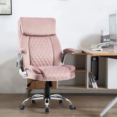 a pink office chair sitting on top of a wooden desk