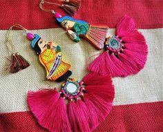 three colorful tassels are laying on a red and white cloth