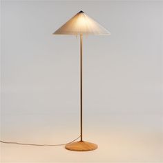 a floor lamp with a wooden base and white lampshade on the top one