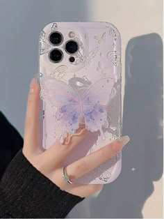 a woman's hand holding an iphone case with a butterfly design on the back