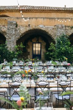 tables and chairs are set up outside for an outdoor wedding reception with flowers in vases