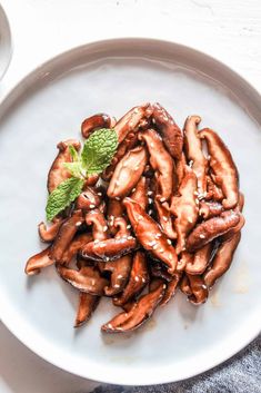 a white plate topped with fried mushrooms covered in sauce