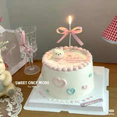 there is a birthday cake with a teddy bear on it and a candle in the middle