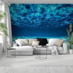 an ocean scene with blue water and clouds in the sky wallpaper mural print on a living room wall