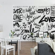 a living room filled with furniture and lots of graffiti on the wall next to a dining table